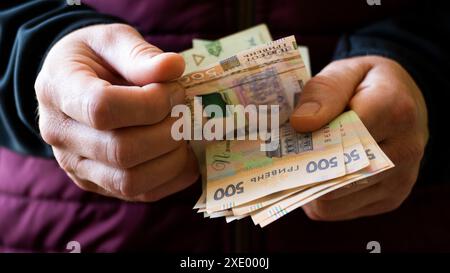 Weißer Mann zählt ukrainische Griwna fünfhundert Scheine in seinen Händen Stockfoto