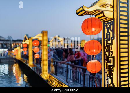 Abendlicher Blick auf traditionelle rote Seidenlaternen auf der malerischen Brücke über den Fluss Thu Bon in Hoi an Ancient Town (Hoian), Vietnam. Fantastisches Straßendekor. Stockfoto