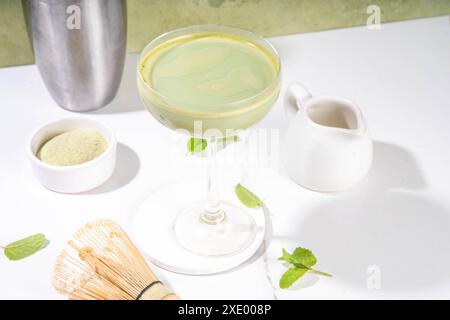 Cremiger Matcha-Martini-Cocktail Matchatini, trendiger kalter Sommercocktail. Matcha alkoholfreier Mocktail oder Alkohol Cocktail, in Martini Gläsern mit GREE Stockfoto