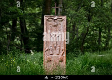 Antike Volkskulptur der Kreuzigung Jesu Christi in der Mitte des Waldes. Contrada Covel, Velo Veronese, Lessinia, Veneto, Italien. Stockfoto