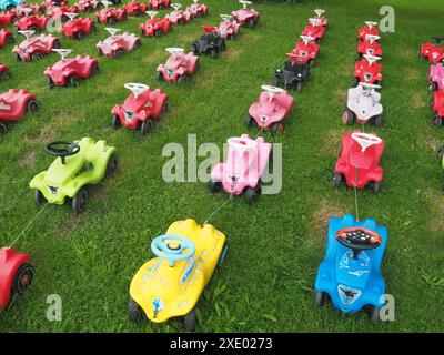 Kinder schieben Autos in Reihen Stockfoto