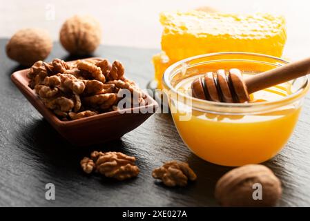 Schiefertablett mit Honigwalnüssen und Honigwabe auf Küchentisch Stockfoto