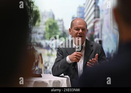 Berlin, Deutschland. Juni 2024. Bundeskanzler Olaf Scholz (SPD) spricht mit Mitarbeitern, nachdem er den Grundstein für das neue Industrie- und Wohnbauprojekt Siemensstädter Platz gelegt hat. Das neue Stadtviertel mit einer Fläche von rund 76 Hektar soll bis 2035 auf dem traditionellen Industriestandort der Siemens AG im Westen der Hauptstadt errichtet werden. Quelle: Ralf Hirschberger/AFP/Pool/dpa/Alamy Live News Stockfoto