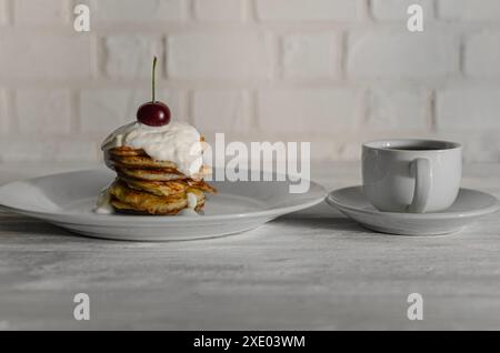 Dünne Pfannkuchen mit Kirschen, Sahne und Kaffee. Frühstück Stockfoto