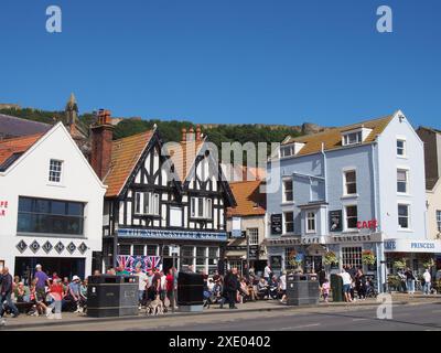 Touristen, die an Cafés und dem newcastle Packet Pub am Sandstrand in scarborough bei Sommersonne vorbeilaufen Stockfoto