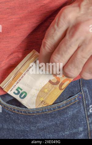 Nahaufnahme eines Mannes, der Euro-Banknoten in der Hosentasche hält Stockfoto