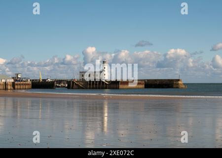 Scarborough Leuchtturm und Hafen spiegeln sich in der Sommersonne am Strand der Südbucht Stockfoto