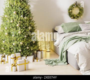 Weihnachten drei mit Ornamenten, festlichen Lichtern und weißen und goldenen Geschenkboxen im Zimmer neben Bett, weihnachtskranz, 3d Stockfoto
