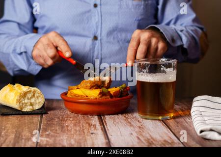 Mann isst Fleischbällchen mit Spaghetti und Bier Stockfoto
