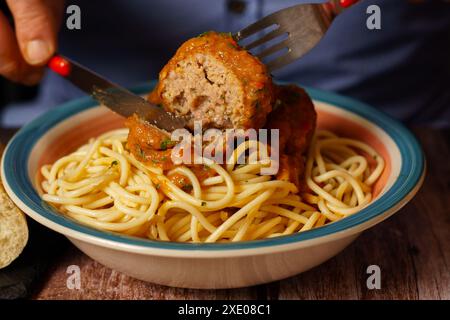 Nahaufnahme eines Tellers Fleischbällchen mit Spaghetti mit Besteck Stockfoto