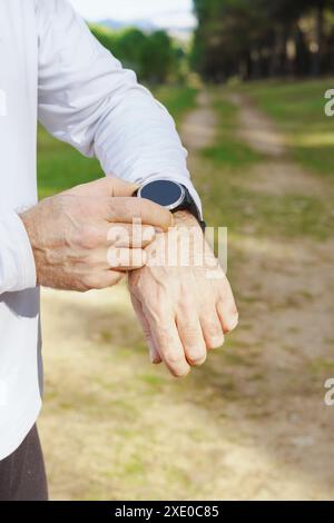 Mann trainiert mit seiner Smartwatch im Feld Stockfoto