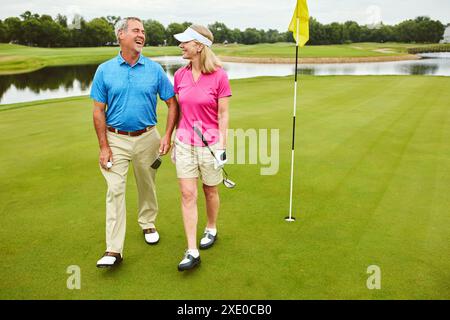 Familie, reifes Paar und Club für Golfsport, körperliche Aktivität und Freizeit. Glückliche Menschen, Mann und Frau, für die wir in der Natur spazieren gehen Stockfoto
