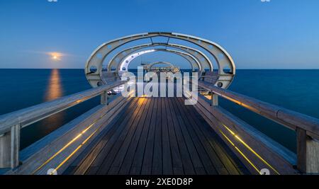 Beleuchtete Pier am Ostseebad Kellenhusen nach Sonnenuntergang. Blick auf das Ostseebad Kel Stockfoto