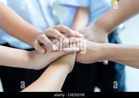 Gruppe von Kindern, die sich die Hände zusammenschließen, Teamarbeit oder Einheit. Kinder, die draußen Hände zusammenlegen, Nahaufnahme. Hilfekonzept Stockfoto