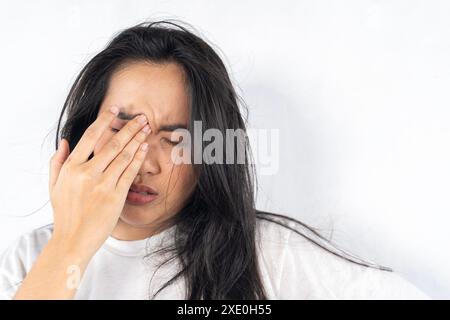 Profilporträt einer jungen attraktiven Frau, die ihre Stirn berührt, an Kopfschmerzen oder Schlafmangel leidet. In Innenräumen. Morgenkrankheit Stockfoto