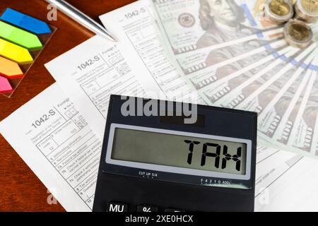 Ein Taschenrechner mit dem Wort "Steuer" steht auf einigen Papieren. Zahlung des Steuersatzes. Steuern, Steuerlast. Wirtschafts- und Steuerkonzept. Stockfoto