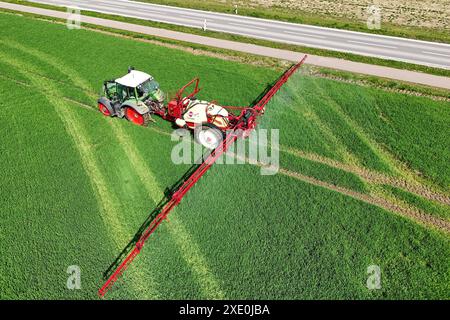 Themenfoto Landwirtschaft,Duengen,Pestizide, ein Landwirt faehrt mit seinenm Traktor ueber ein gruenes Feld und duengt mit Pestiziden. Ein *** Themenfoto Landwirtschaft,Duengen,Pestizide, Ein Landwirt fährt seinen Traktor über ein grünes Feld und düngt mit Pestiziden. Stockfoto