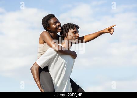 Ein Glückliches Paar Genießt Einen Huckepack-Ritt Am Sonnigen Tag Stockfoto