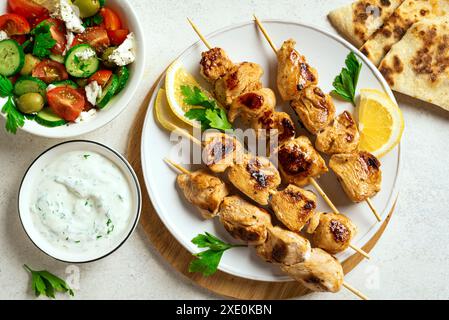 Gegrillte Hähnchenspieße, Joghurt-Sauce und Gemüsesalat. Geröstetes Souvlaki, griechischer Salat, Tzatziki-Dip. Hausgemachte mediterrane gesunde Lebensmittel, Bio Stockfoto