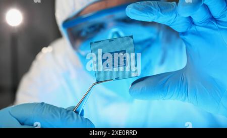 Wissenschaftler Entwickler in Schutzanzug hält Mikroschaltung Stockfoto