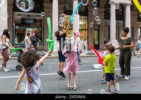 Turin, Italien - 22. Juni 2024: Kinder, die Seifenballons auf der Straße in Turin, Italien, spucken. Stockfoto