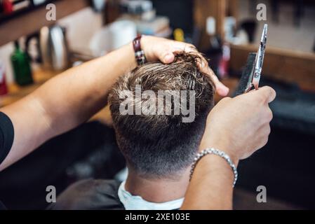 Der Meister im Friseurladen rasiert und schneidet den Mann Stockfoto