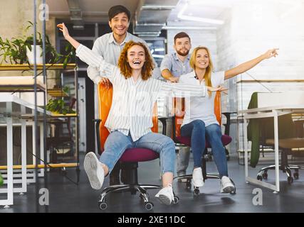 Gerne Kollegen Spaß am Arbeitsplatz, Bürostuhl Rennen Stockfoto