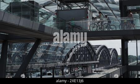 Kinder, die mit dem Fahrrad durch einen hochmodernen Bahnhof in Hamburg fahren Stockfoto