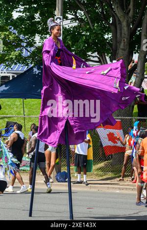 Toronto, ON, Kanada - 5. August 2023: Mädchen, die auf Stelzen die Straße hinunter laufen, während der Caribana Parade in Toronto Stockfoto