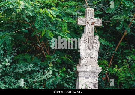 Altes Denkmal von Jesus Christus am Kreuz. Verlassenes Denkmal im Walddickicht. Architektur Stockfoto