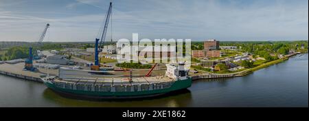 Verankertes Schiff im Hafen, beladen mit Windturbinenschaufeln. Transport von Rotorblättern für Windturbinen auf einem Stockfoto