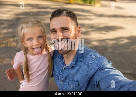Glücklicher Vater und Tochter, die draußen ein Selfie machen Stockfoto