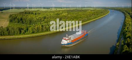 Ein Frachtschiff mit Windturbinenschaufeln navigiert mit einem Windpark im Kieler Kanal Stockfoto