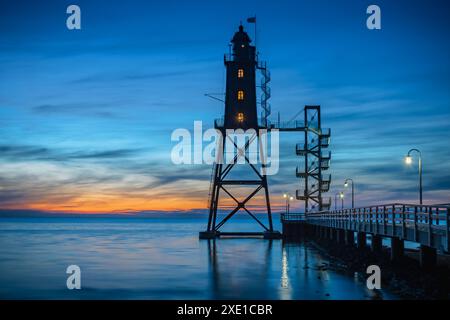 Obereversand Leuchtturm bei Sonnenuntergang. Silhouette des historischen Leuchtturms Obereversand in am Kutterha Stockfoto