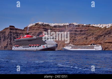 Virgin 'Resilient Lady' und MSC 'Opera' Kreuzfahrtschiffe liegen unter Imerovigli und Fira. Santorin, Kykladen, Griechenland. Stockfoto