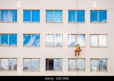 Industrielle Kletterer waschen Fenster an der Fassade eines Gebäudes. Vorderansicht Stockfoto