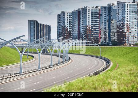 Leere Schnellstraße des westlichen Hochgeschwindigkeitsdurchmessers in St. petersburg bei klarem, sonnigem Wetter, grüne Rasenflächen entlang der Straße, neue Re Stockfoto