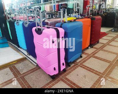 Viele neue mehrfarbige große Kunststoffkoffer auf Rädern. Konzept von Reisen, Urlaub, Tourismus. Stockfoto
