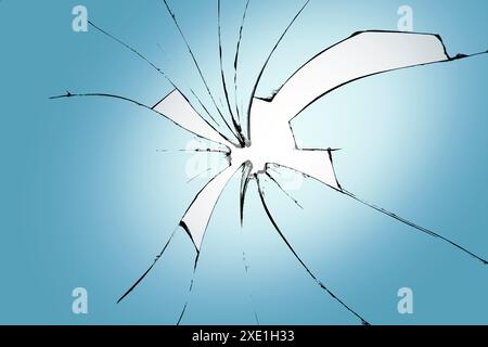 Glasbruch auf blauem Hintergrund, Risse im Glas, abstrakter Hintergrund mit einem Loch in der Mitte. Stockfoto