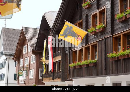 Anton Geisser 20.06.2024 Gasthaus Restaurant Andermatt Schweiz. Bild : Alte Holzhaeuser mit Urner Fahnen Schweizer Alpen Samih Onsi Sawiris *** Anton Geisser 20 06 2024 Gasthaus Restaurant Andermatt Schweiz Bild Alte Holzhäuser mit URI Fahnen Schweizer Alpen Samih Onsi Sawiris Stockfoto