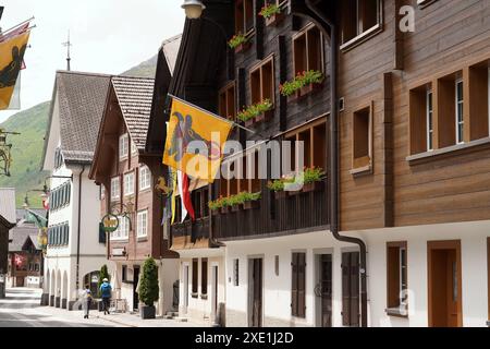 Anton Geisser 20.06.2024 Gasthaus Restaurant Andermatt Schweiz. Bild : Alte Holzhaeuser mit Urner Fahnen Schweizer Alpen Samih Onsi Sawiris *** Anton Geisser 20 06 2024 Gasthaus Restaurant Andermatt Schweiz Bild Alte Holzhäuser mit URI Fahnen Schweizer Alpen Samih Onsi Sawiris Stockfoto