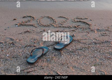 Neujahr 2025, Schriftzug am Strand. Zahlen 2025 Jahr an der Küste, Botschaft handgeschrieben im goldenen Sand auf wunderschönem Strand Hintergrund. Stockfoto