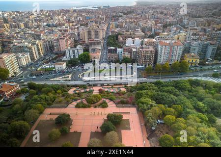 Aus der Vogelperspektive von Catania mit Gebäuden, Straßen und einem grünen Park im Vordergrund, der sich zur Küste hin erstreckt, Highlight Stockfoto