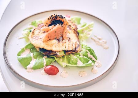 Nahfrühstück mit Kartoffelpfannkuchen mit leicht gesalzenem Lachs, Kräutern und Cremesauce von oben. Mit Platz zum Kopieren. Hochwertige Fotos Stockfoto