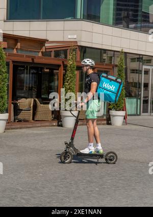 Bratislava, Slowakei - 15. Juli 2023 : Wolt-Kurier bei der Arbeit am Elektroroller in Bratislava. Essenslieferservice. Stockfoto