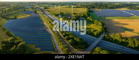 Luftaufnahme der Photovoltaik auf Freiflächen entlang der Autobahn in der Nähe von Rastplätzen. Eine Solaranlage Stockfoto