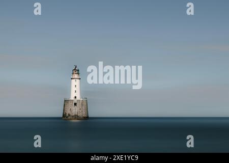 Der Rattray Head Lighthouse steht über den tückischen Sandbänken von Rattray Head, wo die Skelettreste hölzerner Schiffswracks als ein Wächter dienen Stockfoto