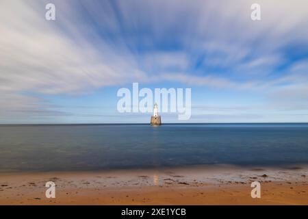 Der Rattray Head Lighthouse steht über den tückischen Sandbänken von Rattray Head, wo die Skelettreste hölzerner Schiffswracks als ein Wächter dienen Stockfoto