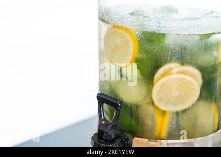 Nahaufnahme eines mit Zitronen- und Gurkenwasser gefüllten Getränkespenders. Stockfoto