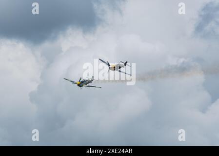 Hispano Buchon-Flugzeuge spielen die Rolle der deutschen Luftwaffe Bf-109 als Ziel für „Dogfight“, wobei ein hinterer Rauch nach dem Treffer ablief Stockfoto